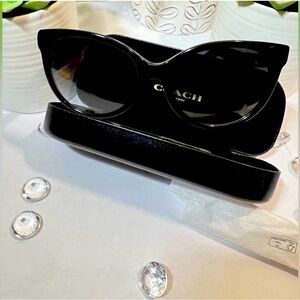 Coach women's sunglasses with a black frame and grey-black gradient lenses.
